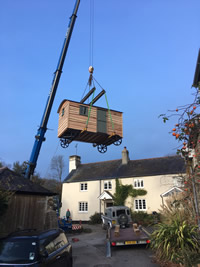 crane moving shepherds hut into position
